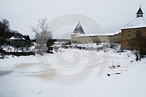 Old Russian fortress in Staraya Ladoga, Russia and the ice-covered river.