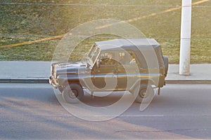 Old Russian military jeep in sunset rays