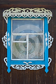 Old Russian window with carved frame with wooden wall.