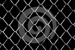 Old rust chain link fence metal wire mesh panel. Black background