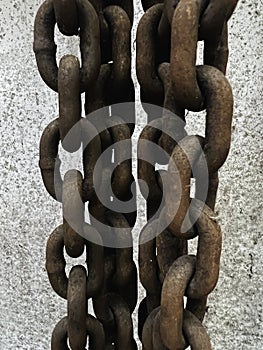 Old and rust iron chain hanging on wall