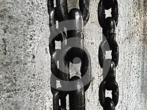 Old and rust iron chain hanging on wall