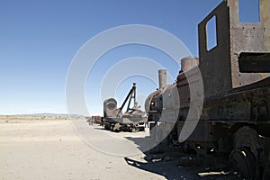 Old rust train in the middle of an empty field under a blue sky