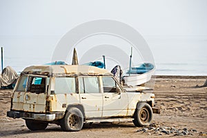 Old rusted 4x4 on a beach in Oman