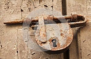 Old Rusted Bolt and Padlock on Wooden Door