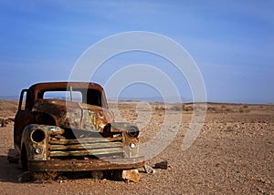 Old rusted car desserted in the desert photo