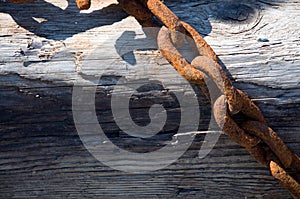 Old Rusted Chain on Weathered Wood at a Marina