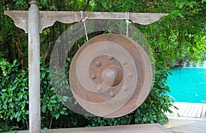 Old rusted gong - Traditional ancient instrument hanging in the midst of nature