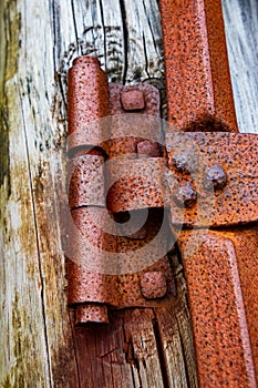 Old Rusted Hinge Bolted To A Weather Worn Wooden post