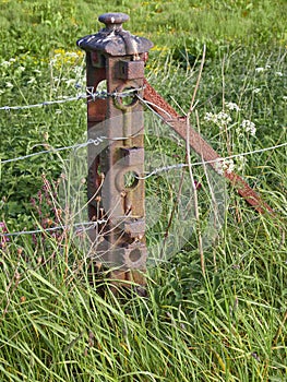 An Old rusted Iron Fencepost in a field near Carmyllie Angus. photo