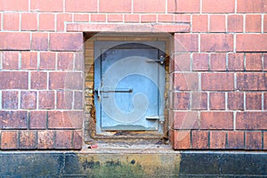 An iron flap on a brick wall