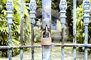 Old rusted lock on blue rusty iron gate