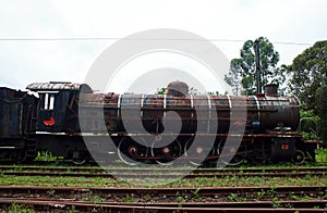 OLD RUSTED STEAM LOCOMOTIVE AT AN ABANDONED STATION