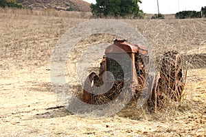 Old, rusted tractor sits in an open field, Cambria CA.
