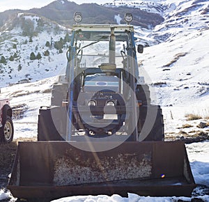 Old rusted tractor in the snowy mountains