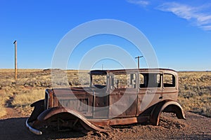 Old rusted vintage car along Route 66, near north entrance of Petrified Forest National Park, USA