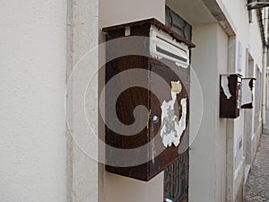 Old, rusted, weathered mailboxes, on a house wall in Portugal