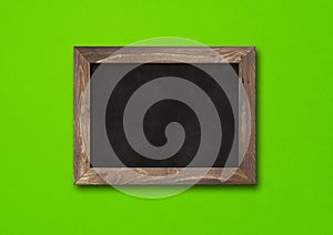Old rustic black board isolated on a green background