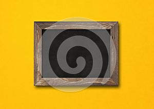 Old rustic black board isolated on a yellow background