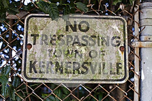 An old rustic black and white No Trespassing sign
