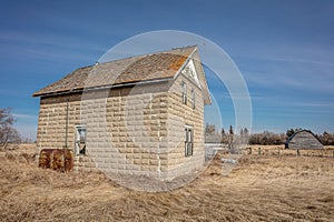 Old rustic brick building in the vast field on a sunny day