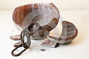 Old rustic chain inside vintage broken clay pot