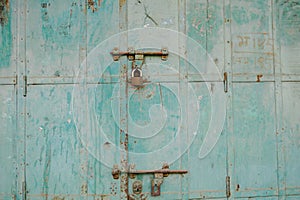 Old rustic door with blue peeling paint,rusty hinges, a  padlock,in Mandawa haveli Rajasthan India