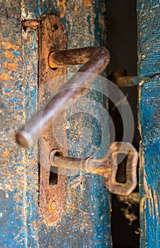 Old rustic door open with rusty lock, key and keyhole