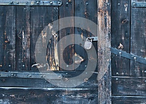 Old rustic faded wood gate with a lock