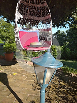 Old rustic hat in swing with pink pillow, romantic