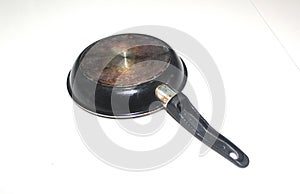 An old and rustic lower side of a frying pan isolated on white background