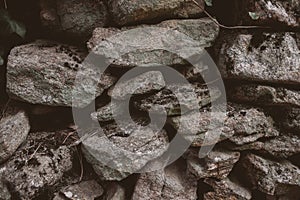 Old rustic wall made of stone. Close up view of abstract stonewall as texture and background.