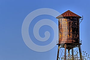 Old, rustic water tower with blue sky background