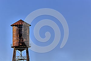 Old, rustic water tower with blue sky background