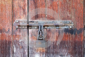 Old and rustic wooden door with a rusty latch