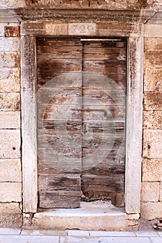 Old rustic wooden doors with stone frame