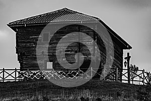 Old rustic wooden house on top of a hill in black and white