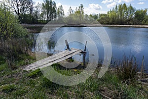 Old rustic wooden jetty on a tranquil lake