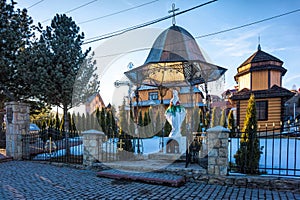 Old rustic wooden orthodox christian church and the statue of the Virgin Mary