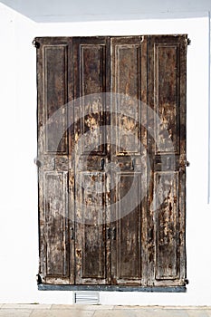Old rustic wooden vintage door in a white house, Ibiza old town