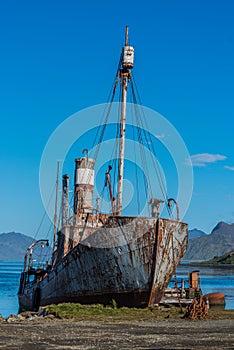 Old rusting whaler moored beneath blue sky photo