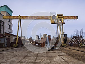 Old rusty abandoned building gantry crane on rusty rails. Abandoned container loading construction warehouse. Dead Zona photo