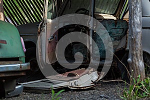 an old rusty abandoned car with its doors open