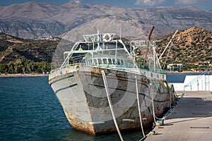 Old rusty abandoned cargo ship at port of Aghia Galini on Crete island