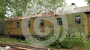 An old rusty abandoned passenger car on abandoned tracks in Germany