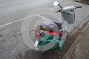 Old rusty and abandoned scooter at the roadside