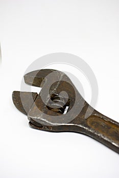 Old, rusty adjustable wrench on a white background close-up