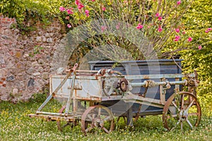 An old rusty agricultural chariot was abandoned in a garden