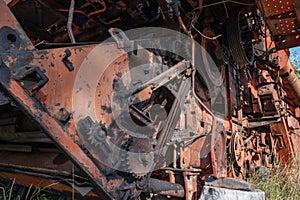 Old rusty agricultural machinery. Close-up Of Abandoned harvester, tractor