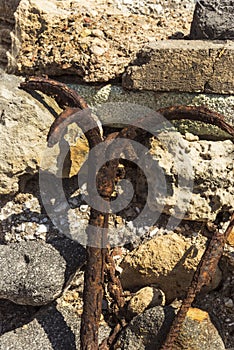 Old rusty anchor on a background of stones